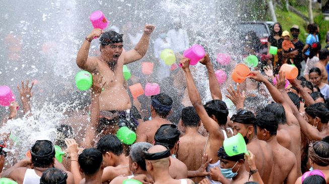 Sejumlah warga saling menyiramkan air saat Tradisi Perang Air dalam rangkaian Festival Air Suwat di Desa Suwat, Gianyar, Bali, Sabtu (1/1/2022).  ANTARA FOTO/Fikri Yusuf
