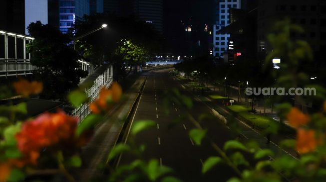 Suasana sepi saat malam pergantian tahun di Jalan Sudirman, Jakarta Pusat, Sabtu (1/1/2022). [Suara.com/Alfian Winanto]
