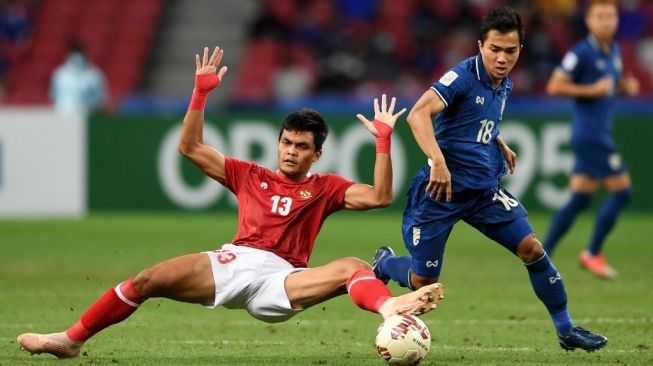Pemain timnas Indonesia Rachmat Irianto (kiri) berebut bola dengan pemain Thailand Chanathip Songkrasin pada pertandingan leg kedua final Piala AFF 2020 antara timnas Indonesia vs Thailand di Stadion Nasional Singapura pada 1 Januari 2022.Roslan RAHMAN / AFP.