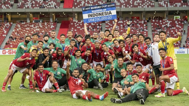 Sejumlah pesepak bola dan tim pelatih Timnas Indonesia berfoto bersama usai pengalungan medali Piala AFF 2020 di National Stadium, Singapura, Sabtu (1/1/2022). Indonesia menduduki juara kedua usai seri melawan Timnas Thailand dengan skor 2-2 atau kalah agregat 2-6. [ANTARA FOTO/Flona Hakim]