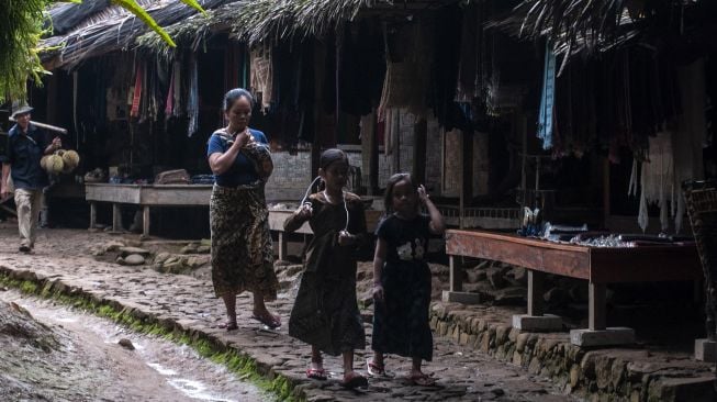 Dua bocah Suku Baduy Luar berjalan di Kampung Kaduketug, Lebak, Banten, Minggu (2/1/2022). [ANTARA FOTO/Muhammad Bagus Khoirunas]