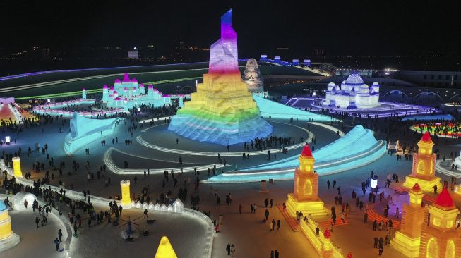 Foto udara menunjukkan orang-orang melihat patung es di Harbin Ice and Snow World, Harbin, Provinsi Heilongjiang, China, pada (25/12/2021). [AFP]