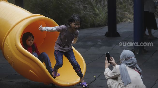 Dua orang anak bermain di Taman Puring, Jakarta, Minggu (2/1/2022). [Suara.com/Angga Budhiyanto]