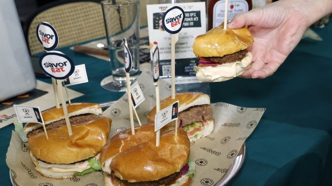 Potongan patty nabati dengan rasa daging yang dibuat dan dimasak oleh robot sesuai dengan kebutuhan pelanggan, dan ditawarkan oleh merek makanan cepat saji Israel BBB di kota pesisir Israel, Herzliya, pada (28/12/2021). [JACK GUEZ / AFP]