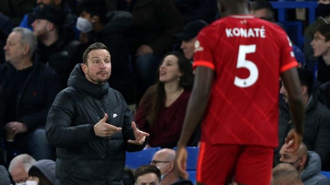 Ekspresi asisten pelatih Liverpool, Pep Lijnders pada laga Liga Inggris kontra Chelsea di Stamford Bridge, London, Senin (3/1/2022) dini hari WIB. [Adrian DENNIS / AFP]