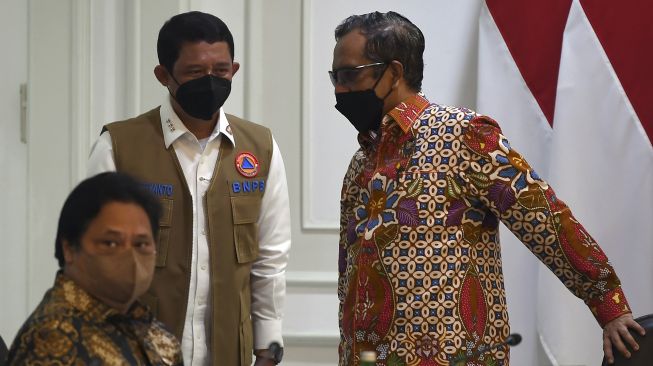 Menko Polhukam Mahfud MD (kanan), Menko Perekonomian Airlangga Hartarto (kiri) dan Kepala BNPB Letjen TNI Suharyanto menghadiri rapat terbatas terkait evaluasi pemberlakuan pembatasan kegiatan masyarakat (PPKM) di Kantor Presiden, Jakarta, Senin (3/1/2022). [ANTARA FOTO/Sigid Kurniawan]