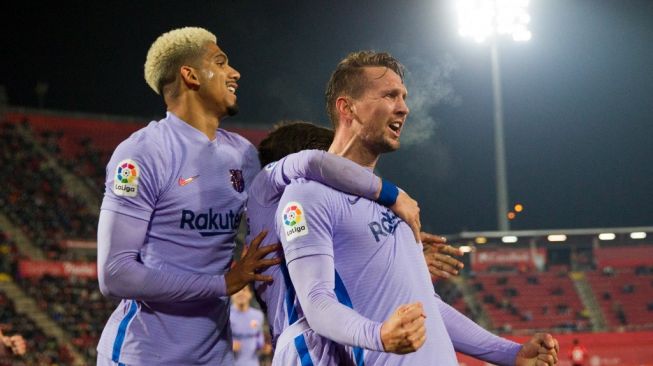 Penyerang Barcelona, Luuk de Jong (kanan) melakukan selebrasi dengan rekan satu timnya setelah mencetak gol dalam pertandingan pekan ke-19 Liga Spanyol antara RCD Mallorca vs Barcelona di stadion Visit Mallorca di Palma de Mallorca, Senin (3/1/2022).JAIME REINA / AFP.