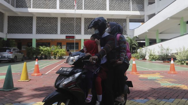 Orang tua murid menjemput anaknya usai mengikuti Pembelajaran Tatap Muka (PTM) di Sekolah Dasar Negeri (SDN) Pondok Labu 01, Jakarta, Senin (3/1/2022). [Suara.com/Angga Budhiyanto]