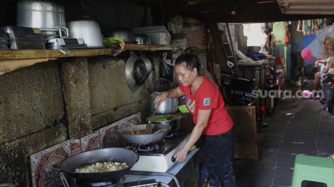 Warga memasak di permukiman padat penduduk Kampung Muka RW 04, Ancol, Pademangan, Jakarta, Selasa (4/1/2022). [Suara.com/Angga Budhiyanto]