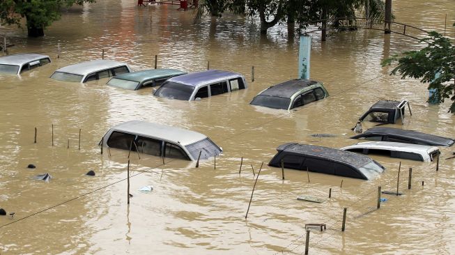 Sejumlah mobil barang bukti Kepolisian terendam saat banjir melanda Kota Lhoksukon, Aceh Utara, Aceh, Senin (3/1/2022). ANTARA FOTO/Rahmad