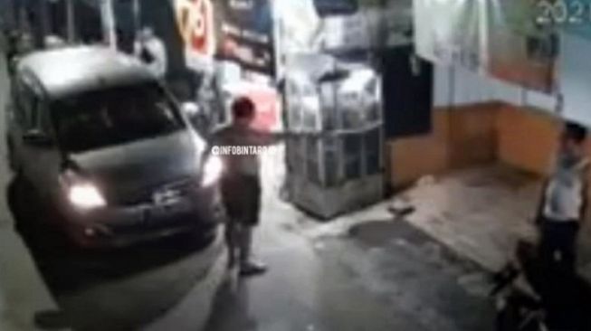 Tangkapan layar video viral seorang pengemudi mobil todongkan senjata diduga pistol ke warga usai tabrak motor di Jalan Haji Sarmah, Perigi, Pondok Aren, Tangerang Selatan (Tangsel). [Instagram@infobintaro.id]
