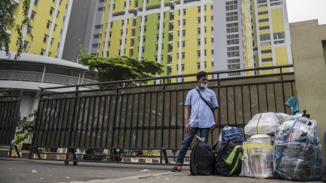 Pekerja Migran Indonesia (PMI) menunggu kendaraan usai menjalani karantina di kompleks Rumah Susun (Rusun) Pasar Rumput, Jakarta, Rabu (5/1/2022). ANTARA FOTO/Galih Pradipta