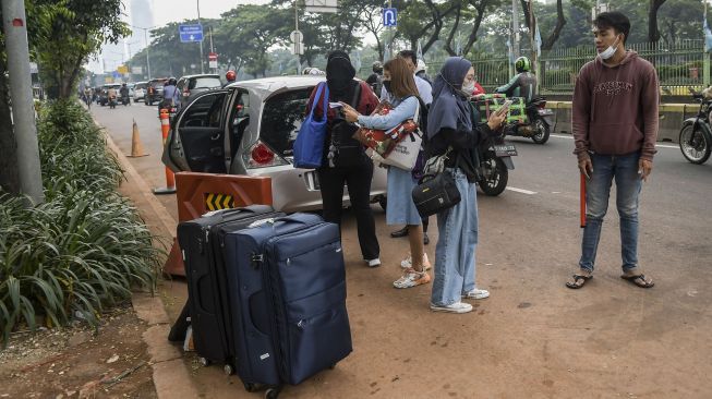 Pekerja Migran Indonesia (PMI) menunggu kendaraan usai menjalani karantina di kompleks Rumah Susun (Rusun) Pasar Rumput, Jakarta, Rabu (5/1/2022). ANTARA FOTO/Galih Pradipta