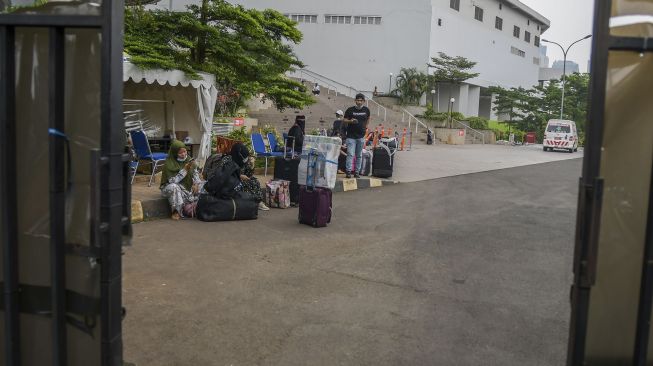 Pekerja Migran Indonesia (PMI) menunggu kendaraan usai menjalani karantina di kompleks Rumah Susun (Rusun) Pasar Rumput, Jakarta, Rabu (5/1/2022). ANTARA FOTO/Galih Pradipta