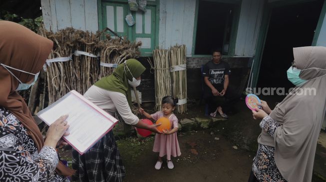 Tenaga kesehatan memberikan sosialisasi pendampingan gizi untuk balita dari pintu ke pintu atau 'door to door' di Desa Purwosari, Kecamatan Sukorejo, Kabupaten Kendal, Jawa Tengah, Kamis (6/1/2021). [Suara.com/Angga Budhiyanto]