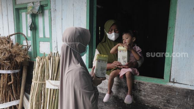 Tenaga kesehatan memberikan sosialisasi pendampingan gizi untuk balita serta manfaat Beras Bervitamin dari pintu ke pintu atau 'door to door' di Desa Purwosari, Kecamatan Sukorejo, Kabupaten Kendal, Jawa Tengah, Kamis (6/1/2021). [Suara.com/Angga Budhiyanto]