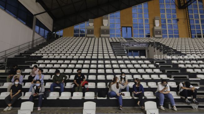 Penonton duduk dengan menjaga jarak dalam kegiatan simulasi kehadiran penonton saat pertandingan basket di Hall Basket Senayan, Jakarta, Jumat (7/1/2022). [Suara.com/Angga Budhiyanto]