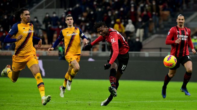 Penyerang AC Milan Rafael Leao menendang bola dan mencetak gol ketiga timnya selama pertandingan sepak bola Serie A Italia AC Milan melawan AS Roma di stadion San Siro, Milan, Italia,  Jumat (7/1/2022) dini hari WIB. Miguel MEDINA / AFP
