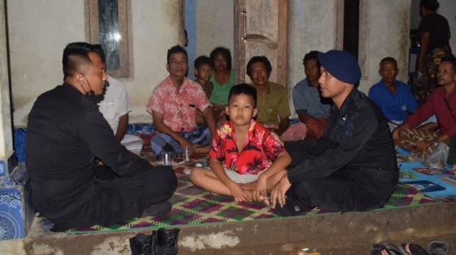 Faris (tengah) saat diserahkan kepada keluarga oleh anggota brimob polres Lombok Tengah yang melakukan penjagaan di Sirkuit Mandalika. [ANTARA/Humas Polres Lombok Tengah]