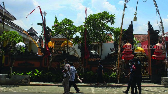 Warga melintas di depan sejumlah tempat ibadah di Universitas Pancasila, jakarta, jumat (7/1/2022).  [Suara.com/Septian]
