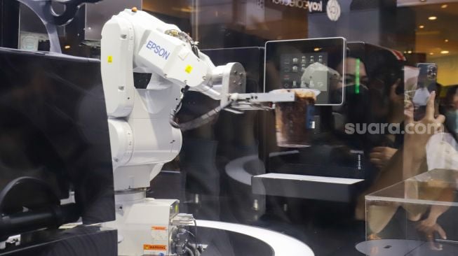 Aksi robot barista membuat minuman kopi di salah satu toko ritel di Grand Indonesia, Jakarta Pusat, Sabtu (8/1/2022). [Suara.com/Alfian Winanto]