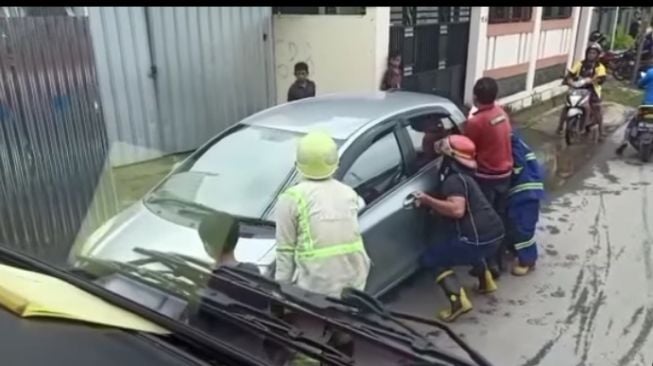 Petugas damkar menyoba mengangkat mobil parkir sembarangan tersebut (Instagram)