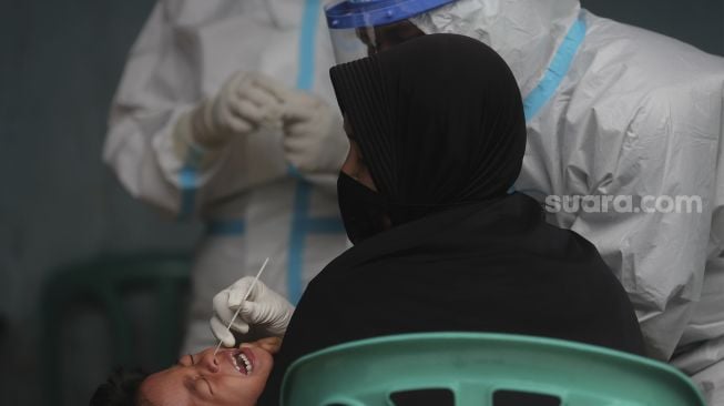 Petugas kesehatan melakukan tes usap (Swab Test) PCR kepada warga di Kelurahan Krukut, Kecamatan Taman Sari, Jakarta, Senin (10/1/2021). [Suara.com/Angga Budhiyanto]