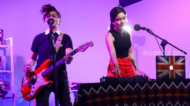 Aksi grup musik Black Champagne ketika tampil saat berkunjung kantor redaksi Suara.com di Kuningan, Jakarta Selatan, Senin (10/1/2021). [Suara.com/Alfian Winanto]