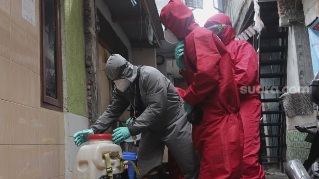 Petugas pemadam kebakaran menyiapkan cairan disinfektan sebelum disemprotkan di Kelurahan Krukut, Kecamatan Taman Sari, Jakarta, Senin (10/1/2021). [Suara.com/Angga Budhiyanto]