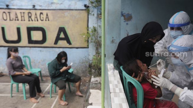 Petugas kesehatan melakukan tes usap (Swab Test) PCR kepada warga di Kelurahan Krukut, Kecamatan Taman Sari, Jakarta, Senin (10/1/2021). [Suara.com/Angga Budhiyanto]