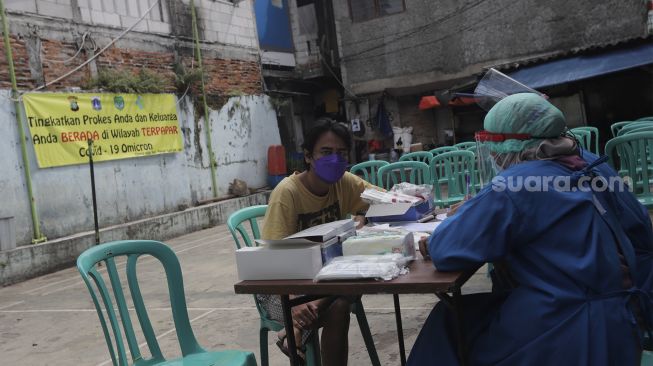 Petugas kesehatan mendata warga yang akan melakukan tes usap (Swab Test) PCR di Kelurahan Krukut, Kecamatan Taman Sari, Jakarta, Senin (10/1/2021). [Suara.com/Angga Budhiyanto]