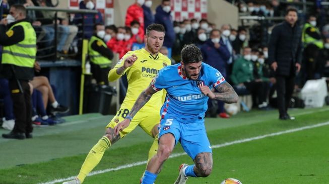 Gelandang Atletico Madrid asal Argentina Rodrigo De Paul (kanan) bersaing dengan bek Villarreal Alberto Moreno dalam pertandingan lanjutan Liga Spanyol antara Villarreal vs Atletico Madrid di stadion La Ceramica, Senin (10/1/2022) dini hari WIB.JOSE JORDAN / AFP.