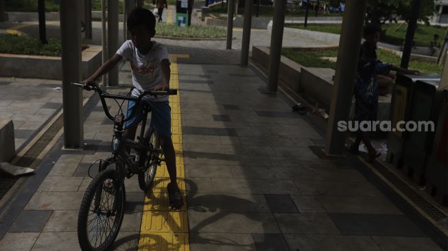 Seorang anak bermain sepeda di kawasan integrasi terpadu Stasiun Manggarai, Kecamatan Tebet, Jakarta Selatan, Senin (10/1/2021). [Suara.com/Angga Budhiyanto]