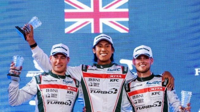 Pebalap Indonesia Sean Gelael (tengah) menunjukkan tropi usai menyelesaikan balapan ketahanan kelas LMP2 FIA World Endurance Championship (WEC) 2021 yang ditutup di Bahrain, Minggu (7/11/2021) dini hari. ANTARA/HO-Tim JOTA/am.