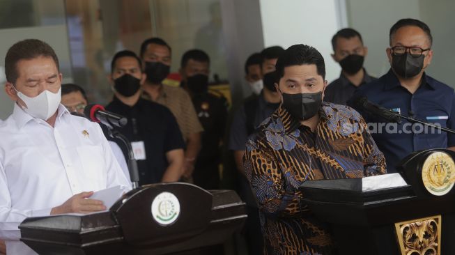 Menteri BUMN Erick Thohir (ketiga kanan) bersama Jaksa Agung ST Burhanuddin (kiri) menyimak pertanyaan wartawan saat memberikan keterangan pers di Gedung Menara Kartika Adhyaksa, Komplek Perkantoran Kejaksaan Agung, Jakarta, Selasa (11/1/2022). [Suara.com/Angga Budhiyanto]