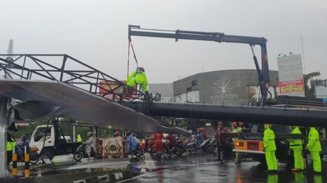 Proses evakuasi baliho ambruk di simpang empat Gejayan, Condongcatur, Depok, Sleman, Rabu (12/1/2022) siang. [Hiskia Andika Weadcaksana / SuaraJogja.id]