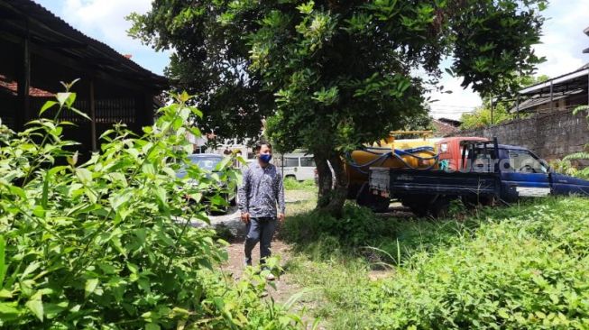 Seorang pegawai melintasi salah satu lahan yang akan digunakan untuk sentra parkir di kompleks Balai Kota Yogyakarta, Selasa (11/1/2022). - (SuaraJogja.id/Muhammad Ilham Baktora)