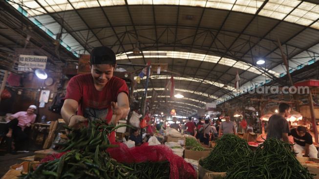 Pedagang memilah cabai di Pasar Induk Kramat Jati, Jakarta, Rabu (12/1/2022). [Suara.com/Angga Budhiyanto]