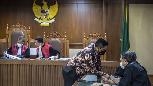 Terdakwa kasus dugaan suap terkait pengurusan atau penanganan sejumlah kasus di KPK Stepanus Robin Pattuju berbincang dengan kuasa hukumnya saat menjalani sidang dengan agenda pembacaan putusan oleh majelis hakim di Pengadilan Tindak Pidana Korupsi (Tipikor), Jakarta, Rabu (12/1/2022). ANTARA FOTO/Muhammad Adimaja