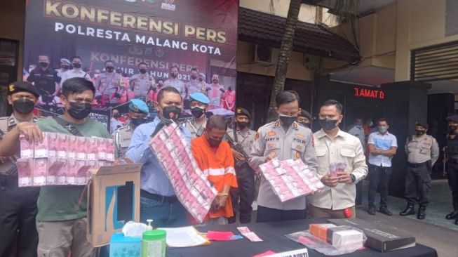 Rilis kasus penipuan dengan kedok penggandaan uang di Mapolresta Malang Kota, Rabu (12/1/2021). [Suara.com/Bob Bimantara Leander]