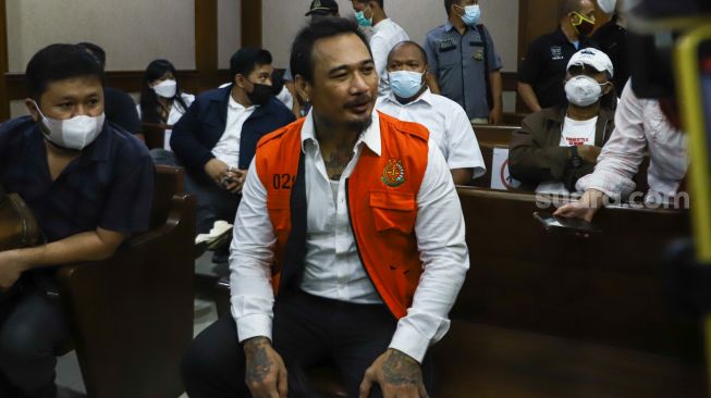 Musisi I Gede Ari Astina atau Jerinx SID saat menunggu untuk menjalani sidang kasus pengancaman di Pengadilan Negeri Jakarta Pusat, Rabu (12/1/2022). [Suara.com/Alfian Winanto]