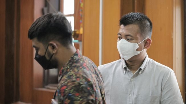 Dua terdakwa kasus penganiayaan wartawan Tempo Nurhadi, Brigadir Polisi Kepala Purwanto (kanan) dan Brigadir Polisi Muhammad Firman Subkhi (kiri) menjalani sidang putusan di Pengadilan Negeri Surabaya, Surabaya, Jawa Timur, Rabu (12/1/2022). ANTARA FOTO/Rizal Hanafi