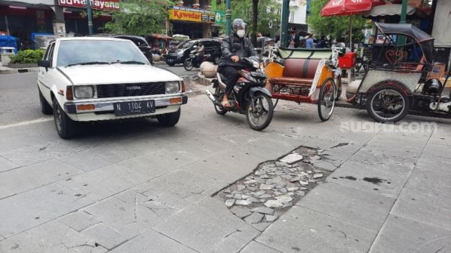 Sejumlah kendaraan melintas di sekitar titik batu granit yang pecah di Jalan Perwakilan yang baru diresmikan pada 31 Desember 2021 lalu, Kamis (15/1/2022). - (SuaraJogja.id/Muhammad Ilham Baktora)