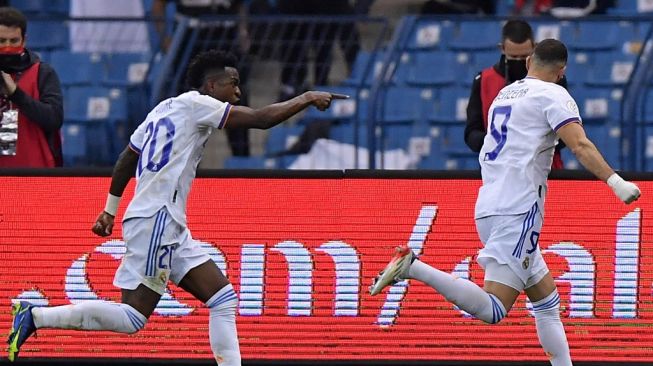 Penyerang Real Madrid, Karim Benzema (kanan) bersama Vinicius Junior merayakan gol dalam laga semifinal Piala Super Spanyol 2022 antara Barcelona vs Real Madrid di stadion Internasional Raja Fahad, Riyadh, Arab Saudi, Kamis (13/1/2022) dini hari WIB. [AFP]