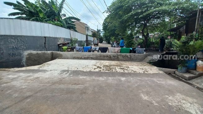 Warga di RT 09 RW 10, Pondok Bambu, Duren Sawit, Jakarta Timur terpaksa membeton jalanan karena tak kunjung mendapat solusi dari pemerintah soal masalah banjir. (Suara.com/Yaumal)