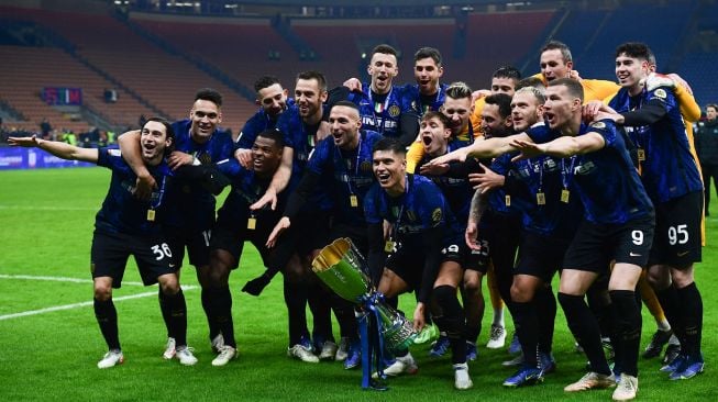 Para pemain Inter Milan merayakan dengan membawa trofi pemenang setelah memenangkan pertandingan sepak bola Piala Super Italia antara Inter melawan Juventus di Stadion Giuseppe-Meazza, Kamis (13/1/2022) dini hari WIB. [Foto AFP]