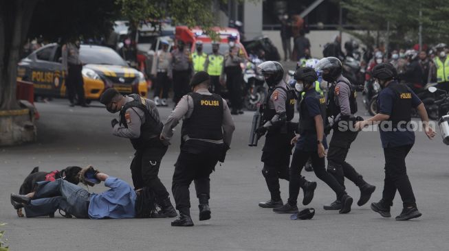 Anggota polisi dengan anjing pelacak melakukan simulasi penangkapan pelaku kejahatan dalam upacara peresmian tim Perintis Presisi Polda Metro Jaya di Lapangan Presisi Polda Metro Jaya, Jakarta, Kamis (13/1/2022). [Suara.com/Angga Budhiyanto]