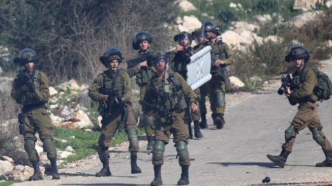 Tentara Israel bersiaga dengan senjata mereka dalam bentrokan dengan pengunjuk rasa Palestina di dekat Kota Nablus, Tepi Barat, Desember 2020. [Dok.Antara]