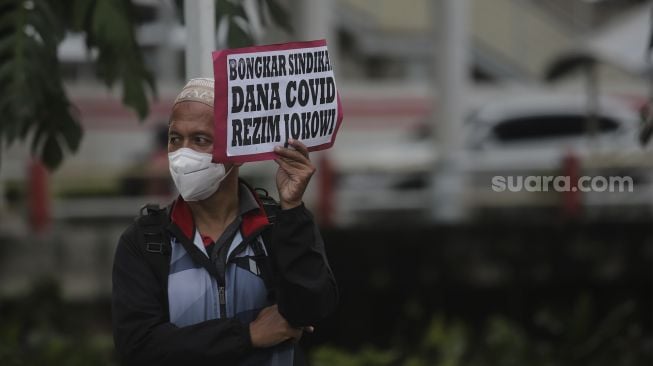 Massa yang tergabung dalam Aliansi Rakyat Menggugat (ARM) membawa poster saat melakukan aksi unjuk rasa di sekitar Gedung Komisi Pemberantasan Korupsi (KPK), Jakarta, Kamis (13/1/2022). [Suara.com/Angga Budhiyanto]