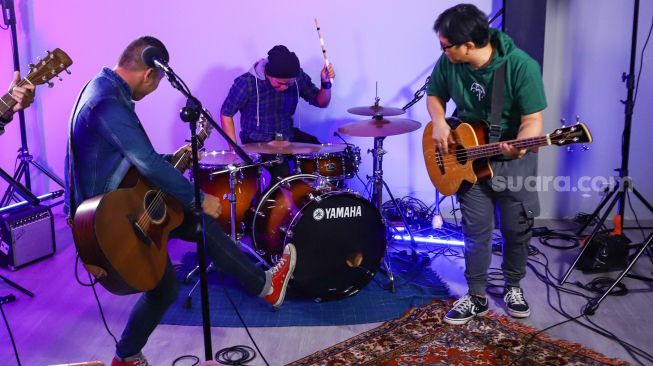 Aksi Band The Rain ketika tampil bernyanyi saat berkunjung ke kantor redaksi Suara.com di Kuningan, Jakarta Selatan, Kamis (13/1/2022). [Suara.com/Alfian Winanto]